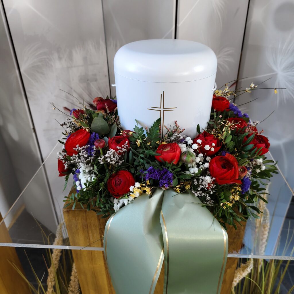 Urnenschmuck mit roten und weißen Blumen – Bestattungsfloristik Vöcklabruck